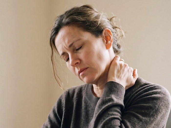 Woman at her desk holding her stiff neck